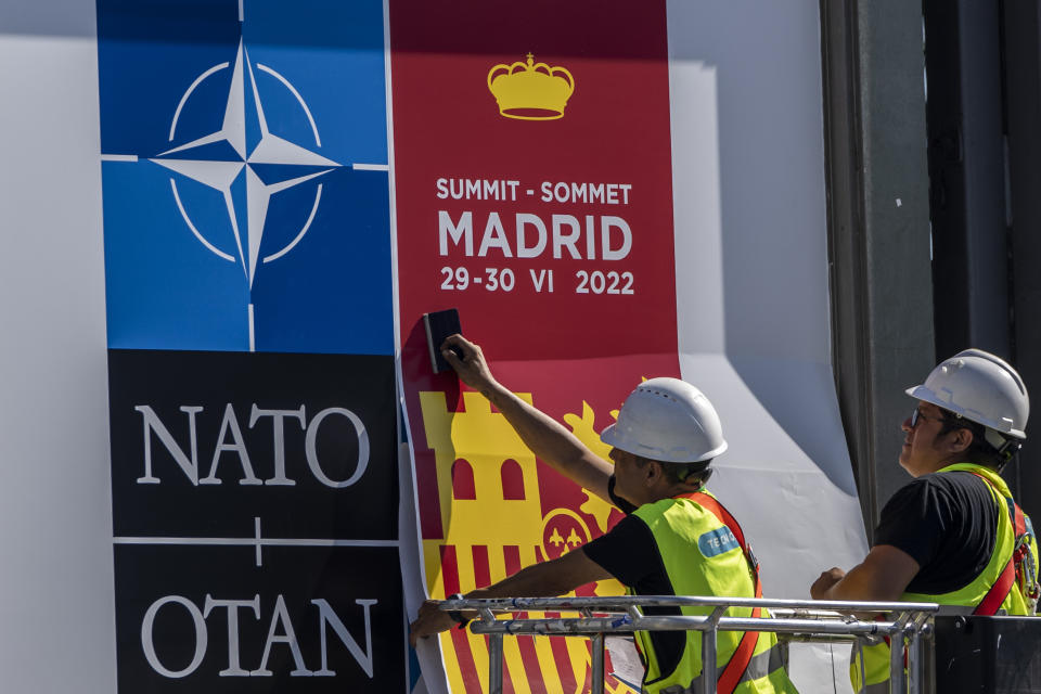 FILE - A worker fixes a NATO poster outside the NATO Summit building ahead of the summit in Madrid, Spain, Monday, June 27, 2022. Seven decades after it was founded, the North Atlantic Treaty Organization is meeting in Madrid this week with an urgent need to reassert its original mission: preventing Russian aggression against Western allies. (AP Photo/Manu Fernandez, File)