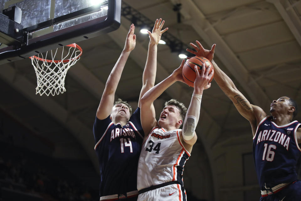 Oregon State forward Tyler Bilodeau (34) is fouled by Arizona center Motiejus Krivas (14) as Arizona forward Keshad Johnson (16) defends during the first half of an NCAA college basketball game Thursday, Jan. 25, 2024, in Corvallis, Ore. (AP Photo/Amanda Loman)