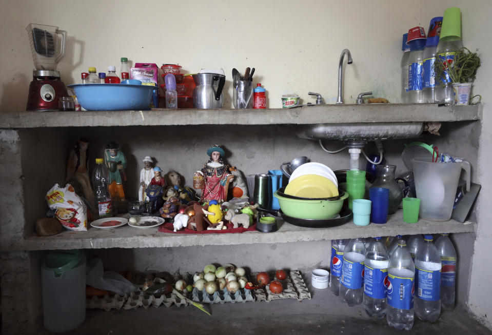 Verduras, utensilios, juguetes y figuras de santos populares se ven en la cocina de la familia Primera Pulido en Cúcuta, Colombia, el jueves 2 de mayo de 2019. (AP Foto/Fernando Vergara)