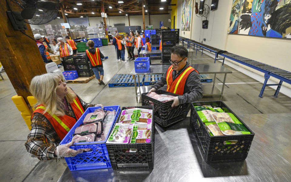 Volunteers sort through food donated by Amazon Fresh at a grocery rescue station inside Second Harvest Food Bank in Irvine, CA, on Thursday, December 1, 2022.<span class="copyright">Jeff Gritchen––MediaNews Group/Orange County Register via Getty Images</span>