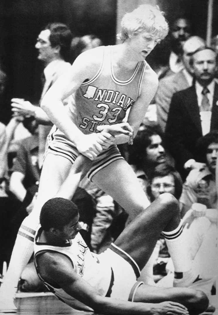 In this March 30, 1979 file photo, Indiana State's Larry Bird (33) gives a helping hand to a fallen Magic Johnson of Michigan State during the final game of the NCAA men's basketball championship in Salt Lake City. Showtime is about to have a whole new meaning for Magic Johnson. The story of his rivalry and friendship with Larry Bird has been made into a play, opening in New York in April. (AP Photo/File)