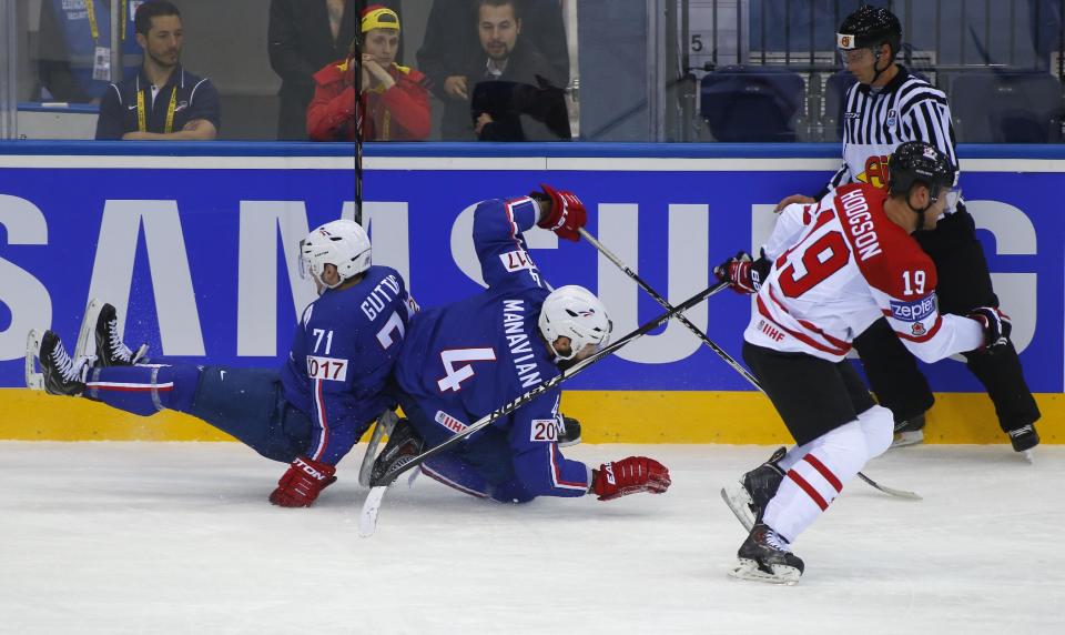 Canada's Cody Hodgson, right, and France's Anthony Guttig, left, Antonin Manavian, center, battle for the puck during the Group A preliminary round match between Canada and France at the Ice Hockey World Championship in Minsk, Belarus, Friday, May 9, 2014. (AP Photo/Sergei Grits)