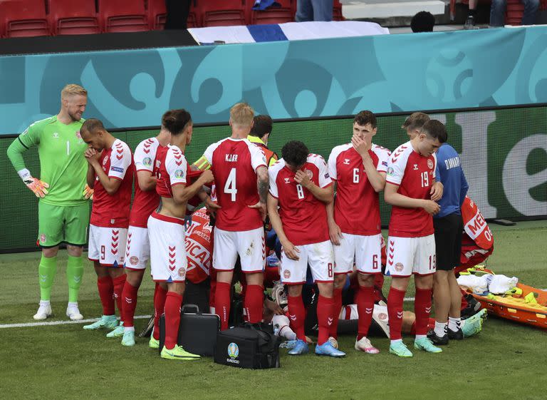 Los jugadores de Dinamarca reaccionan cuando su compañero de equipo Christian Eriksen yace en el suelo durante el partido del grupo B del campeonato de fútbol de la Eurocopa 2020 entre Dinamarca y Finlandia en el estadio Parken en Copenhague