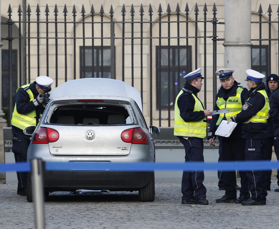 Police officers examine a car in the driveway to the Presidential Palace in Warsaw, Poland, Tuesday, Jan. 22, 2019 after a man rammed the car into a metal barrier protecting the driveway. The man was driving the wrong way and hit a policeman who was trying to stop him before ramming into the barrier. (AP Photo/Czarek Sokolowski)