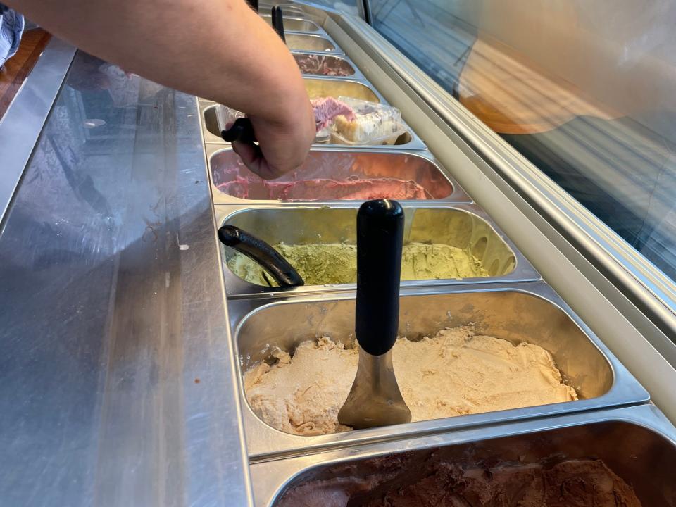 O.J. Molinaro, who opened Aunt G's Italian Kitchen in Fort Pierce, scoops gelato for a customer on July 25, 2023.
