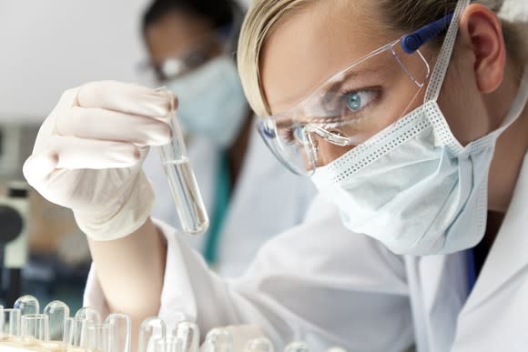 Lab worker examining a sample vial.