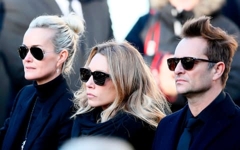 French rock star Johnny Hallyday's wife Laeticia, left, his daughter Laura Smet, and son David Hallyday, right, arrive at La Madeleine church for his funeral ceremony in Paris.  - Credit: AP