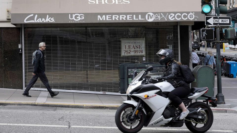 PHOTO: A pedestrian and motorcyclist pass by a closed footwear store in San Francisco, Calif., on July 6, 2023. (John G. Mabanglo/EPA via Shutterstock)
