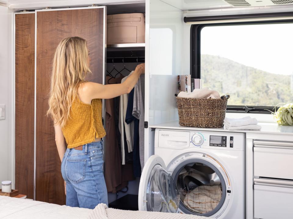 a person opening the closet and washer