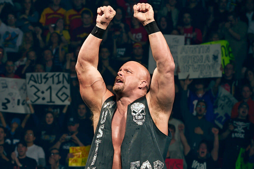 Stone Cold Steve Austin climbing the ropes of the ring with his fists up