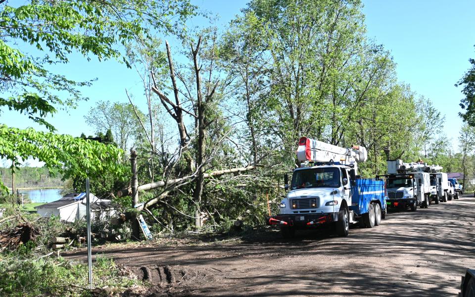 Consumer Energy crews prepare to replace power poles on Ralston Road into the Blossom Lake area Friday afternoon.
