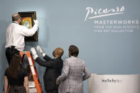 Sotheby's staff hang Pablo Picasso's "Femme au béret rouge-orange," the highest selling piece, ahead of an auction at the Bellagio hotel and casino Saturday, Oct. 23, 2021, in Las Vegas. Sotheby's and the MGM Resorts Fine Art Collection hosted the auction, which raised $109 million from eleven pieces. (AP Photo/Ellen Schmidt)