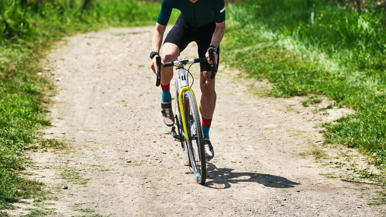 a man riding a bicycle on a dirt road