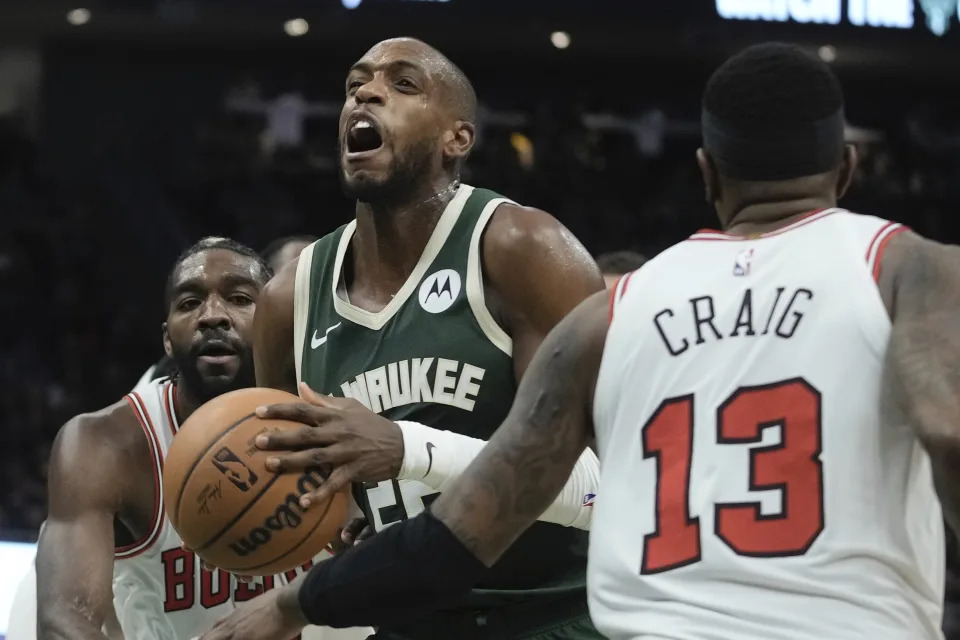 Milwaukee Bucks' Khris Middleton is fouled driving between Chicago Bulls' Patrick Williams and Torrey Craig during the first half of an NBA basketball game Monday, Dec. 11, 2023, in Milwaukee. (AP Photo/Morry Gash)