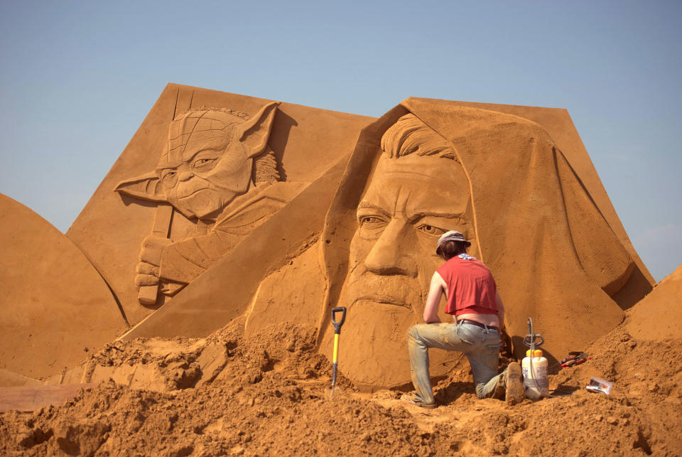 <p>A sand carver works on a sculpture during the Sand Sculpture Festival “Disney Sand Magic” in Ostend, Belgium. (Photo courtesy of Disneyland Paris) </p>