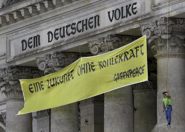 Activists of Greenpeace extendet the inscription ‘Dem deutschen Volke’ (To the German People) on top of the entrance of the Reichstag building (Michael Sohn/AP)