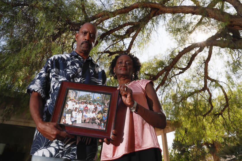 Claremont, CA, Thursday, September 15, 2022 - Edward (Juan) and Phyllis Stricklan are the parents of a man with serious mental illness who is incarcerated in the mental unit of LA County Twin Towers facility. They hold a photo from a NAMI sponsored event showing them with their son and numerous friends who were there to support them. (Robert Gauthier/Los Angeles Times)