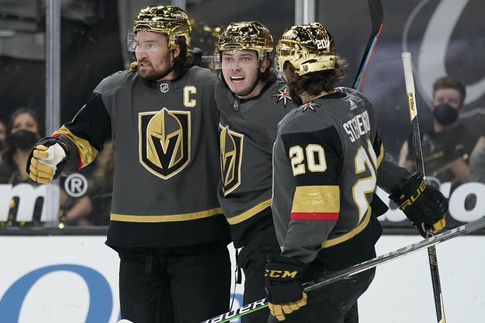 Vegas Golden Knights' Mark Stone, left, and Chandler Stephenson, right, celebrate after Cody Glass, center, scored against the Minnesota Wild during the second period of an NHL hockey game Monday, March 1, 2021, in Las Vegas. (AP Photo/John Locher)