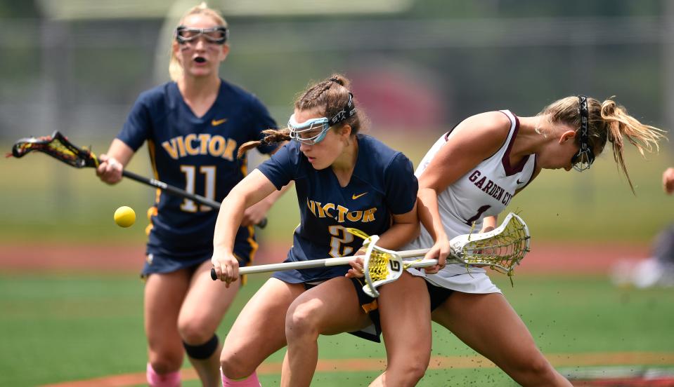 Victor's Allie Pisano, left, reaches for a loose ball against Garden City's Kendal Morris during the NYSPHSAA Girls Lacrosse Championships Class B final in Cortland, N.Y., Saturday, June 10, 2023. Victor won the Class B title with an 8-6 win over Garden City.