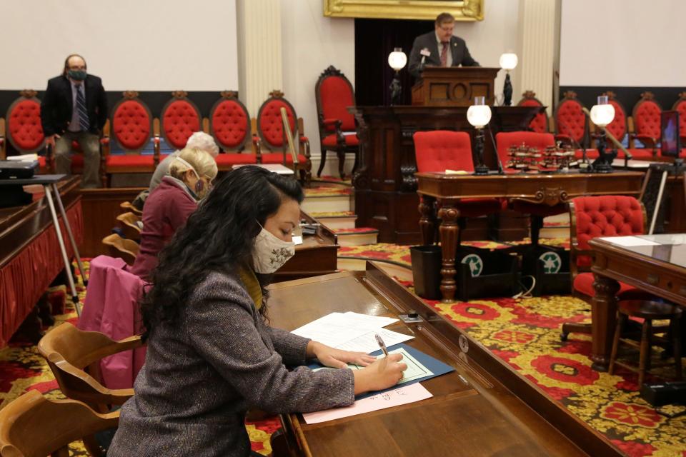 Vermont Presidential elector Kesha Ram fills out her presidential ballot at the Statehouse in Montpelier, Vt., on Monday, Dec. 14, 2020.