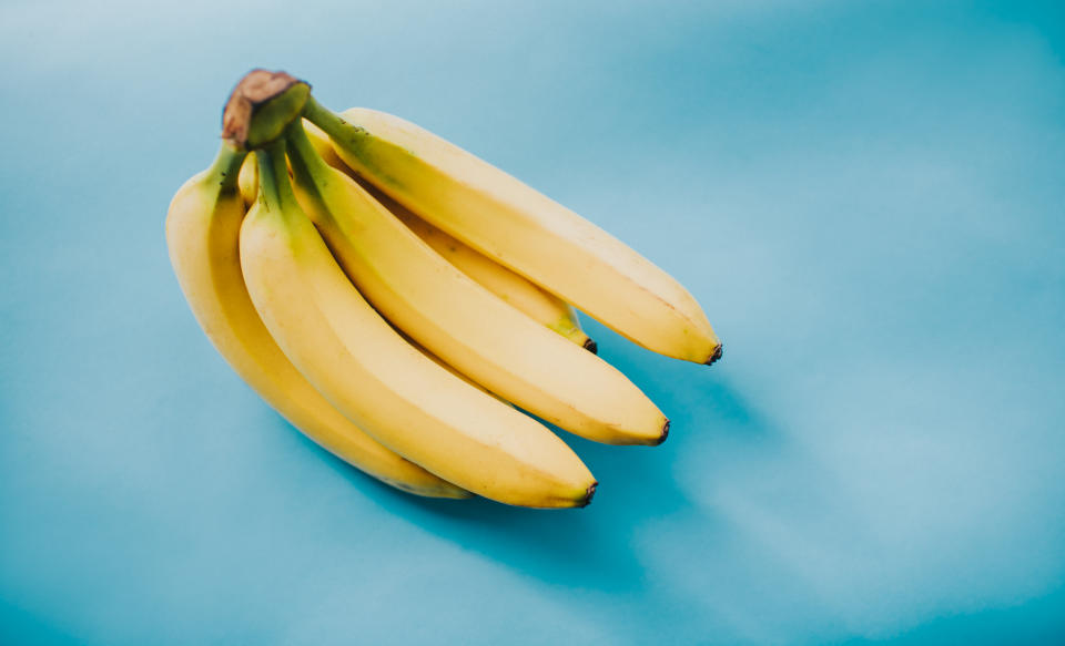 Bunch of Bananas on a blue backdrop. Space for copy.