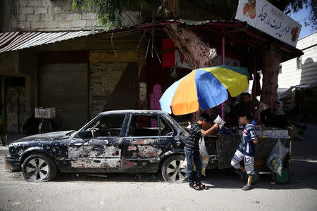 Children buy snacks from a cart vendor in the rebel held besieged city of Douma, in the eastern Damascus suburb of Ghouta, Syria May 10, 2017. REUTERS/Bassam Khabieh