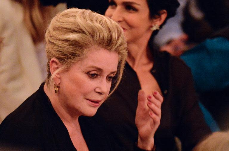 French actress Catherine Deneuve (L)attends a Paris fashion show on September 28, 2013