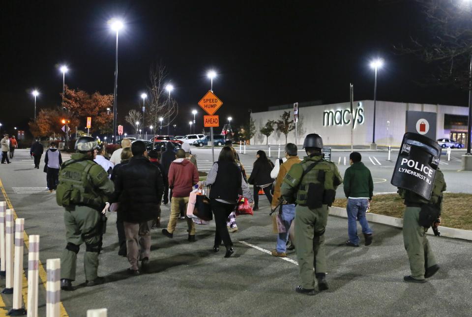 Policemen escort workers and shoppers from the Garden State Plaza mall after a lock down during police response to reports that a gunman had fired shots, in Paramus