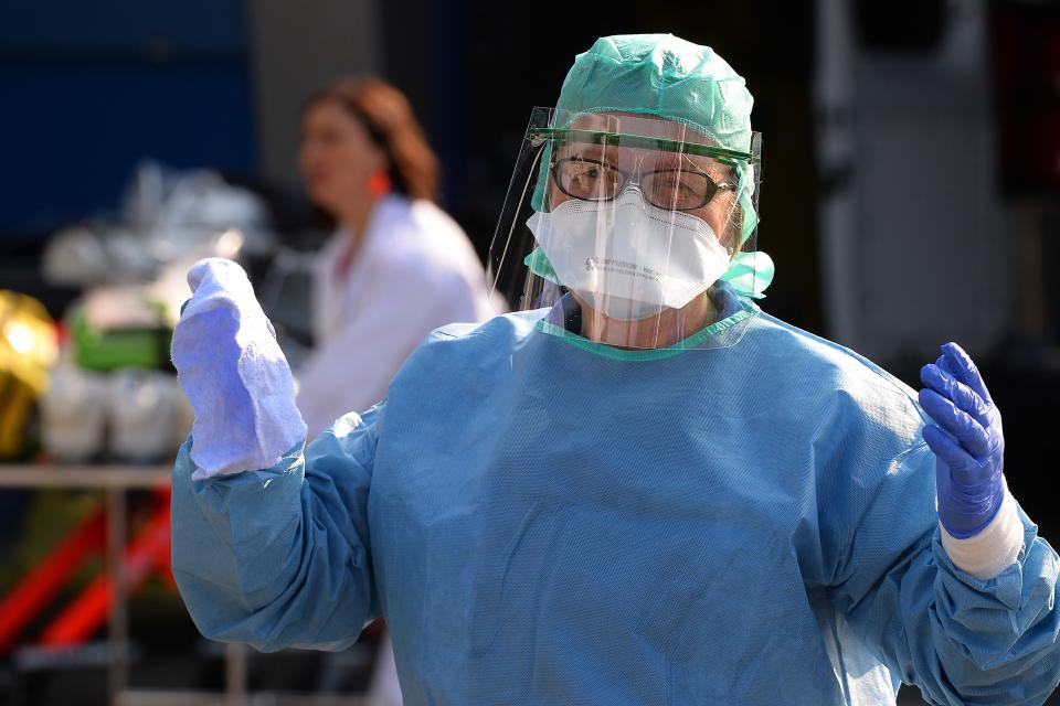 A nurse anesthetist gestures during the disinfection of ambulances which carried six coronavirus patients at the Brest hospital, evacuated by air from the French eastern city of Mulhouse, in Brest, western France, on March 24, 2020, on the eight day of a lockdown aimed at curbing the spread of the COVID-19 (novel coronavirus) in France. (Photo by JEAN-FRANCOIS MONIER / AFP) (Photo by JEAN-FRANCOIS MONIER/AFP via Getty Images)