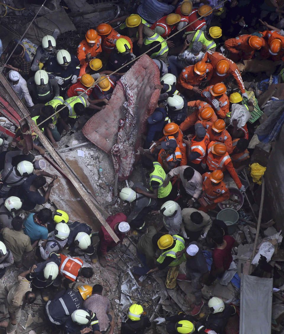 Rescuers work at the site of a building that collapsed in Mumbai, India, Tuesday, July 16, 2019. A four-story residential building collapsed Tuesday in a crowded neighborhood in Mumbai, India's financial and entertainment capital, and several people were feared trapped in the rubble, an official said. (AP Photo/Rajanish Kakade)