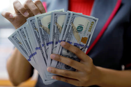 An employee counts U.S. dollar banknotes at a currency exchange office in Jakarta, Indonesia October 23, 2018. Picture taken October 23, 2018. REUTERS/Beawiharta