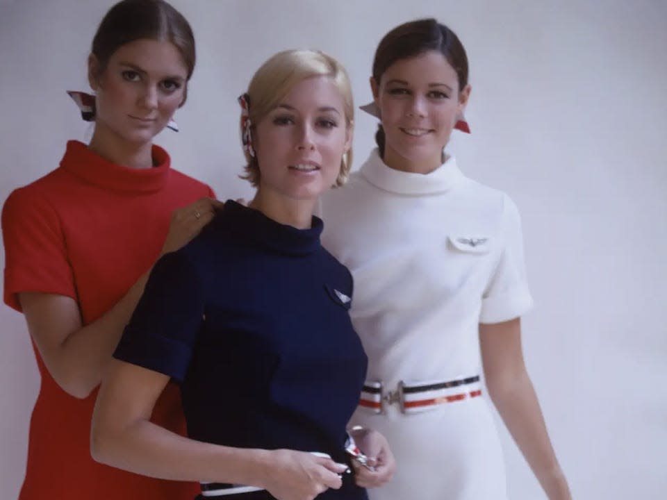 Three women model uniforms for American Airlines in September 1967.