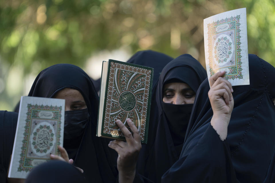 Iraqis raise copies of the Quran, Muslims' holy book, during a protest in Baghdad, Iraq, Saturday, July 22, 2023. Hundreds of protesters have attempted to storm Baghdad’s heavily fortified Green Zone, which houses foreign embassies and the seat of Iraq’s government, following reports of the burning of a Quran by a ultranationalist group in front of the Iraqi Embassy in Copenhagen. (AP Photo/Hadi Mizban)