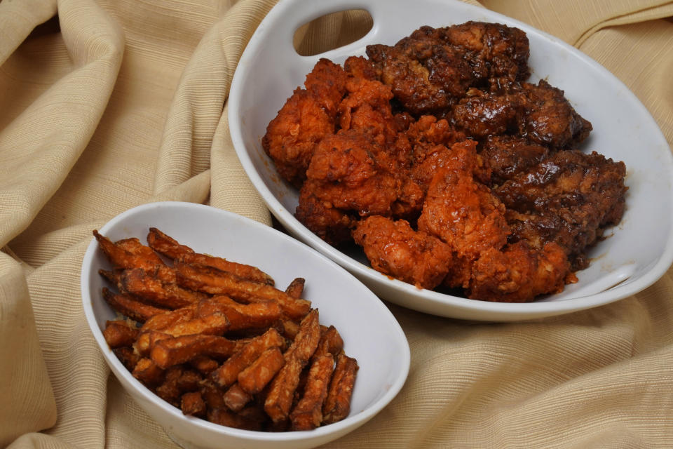"Boneless chicken wings", with two sauces, and an order of sweet potato fries, from a restaurant in New York, are shown in this photo, Wednesday, Feb. 8, 2023. With the Super Bowl at hand, behold the untruth that has been perpetrated upon (and with the full blessing of) the chicken-consuming citizens of the United States: A “boneless wing” isn’t a wing at all. (AP Photo/Richard Drew)