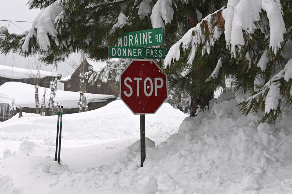 A stop sign is half buried in snow in a Donner Lake neighborhood on Friday, March 4, 2024, in Truckee, Calif. A powerful blizzard that closed highways and ski resorts had moved through the Sierra Nevada by early Monday, but forecasters warned that more snow was on the way for the Northern California mountains. More than 7 feet (2.1 meters) of snow fell in some locations and fierce winds lashed the Sierra over the weekend. (AP Photo/Andy Barron)