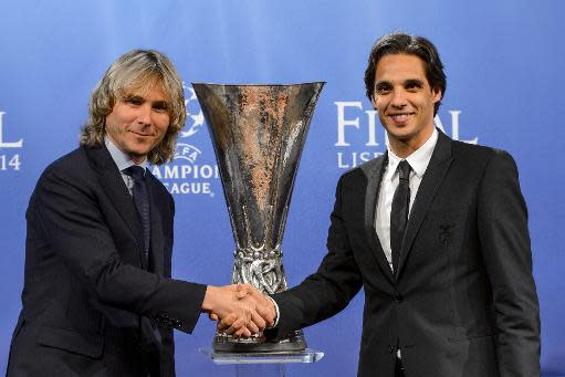 El representantes de la Juventus, Pavel Nedved (izq), y el del Benfica, Nuno Gomes, se estrechan la mano ante el trofeo de la Europa League este viernes 11 de abril en Nyon (Suiza), tras el sorteo de semifinales de la competición (AFP | Fabrice Coffrini)