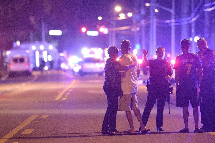 Agentes de la policía de Orlando hablan con familiares para que se alejen del lugar en el que ocurrió el ataque. (AP)