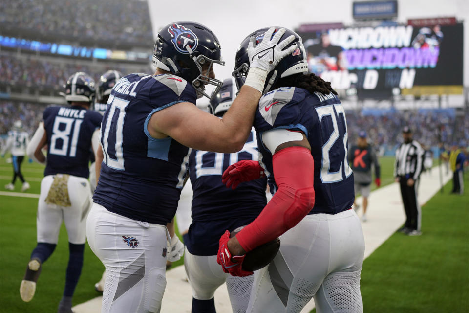 Tennessee Titans running back Derrick Henry (22) is congratulated by Daniel Brunskill (60) after Henry scored his second touchdown during the first half of an NFL football game against the Carolina Panthers Sunday, Nov. 26, 2023, in Nashville, Tenn. (AP Photo/George Walker IV)
