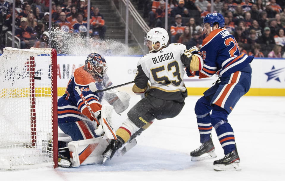 Vegas Golden Knights' Teddy Blueger (53) is stopped by Edmonton Oilers goalie Stuart Skinner (74) as Mattias Janmark (26) defends during the third period of an NHL hockey game Saturday, March 25, 2023, in Edmonton, Alberta. (Jason Franson/The Canadian Press via AP)