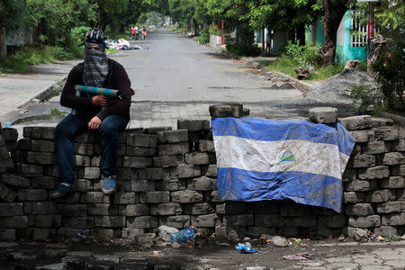 A man holding a homemade mortar sits on a roadblock in Managua, Nicaragua June 16, 2018. REUTERS/Oswaldo Rivas