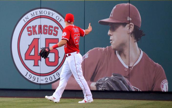 Angels center fielder Mike Trout gestures toward a photo of Tyler Skaggs prior to a game in 2019.