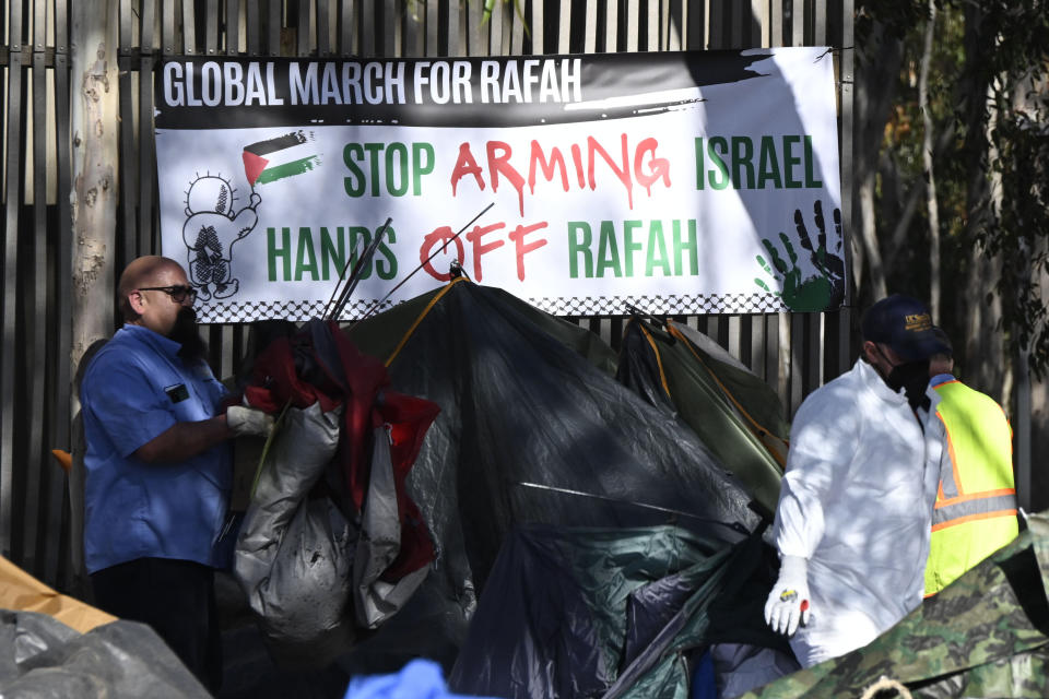 Workers remove tents and debris from a Pro-Palestinian encampment set up in front of Geisel Library at UC San Diego, Monday, May 6, 2024, in San Diego. Police cleared the campus encampment in the early morning Monday. (AP Photo/Denis Poroy)