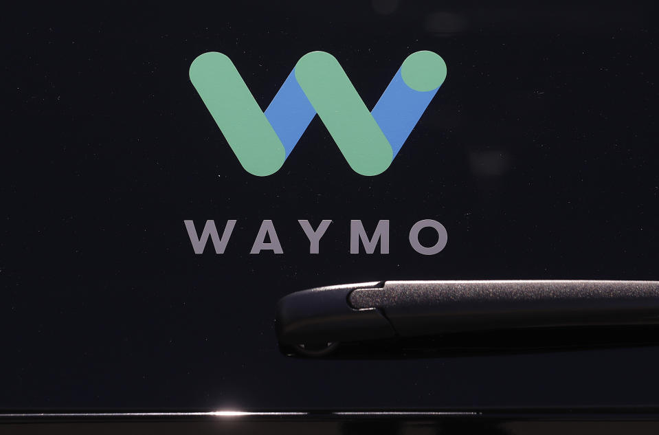 FILE - This Tuesday, May 8, 2018, file photo shows a Waymo logo displayed on the window of a car at the Google I/O conference in Mountain View, Calif. Google autonomous vehicle spinoff Waymo says it will start testing on public roads in Florida in August 2019 to better experience heavy rain. The Mountain View, California, company says tests will include highway driving to Orlando, Tampa and Fort Myers. (AP Photo/Jeff Chiu, File)