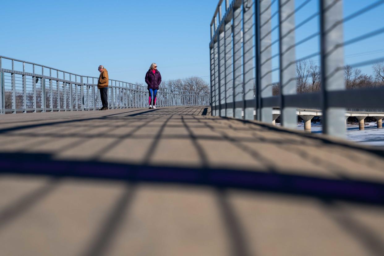 Des Moines residents Laurie and Ward Phillips take a stroll acrossa bridge at Gray's Lake Park in Des Moines. The  streak of warm weather that set in at the end of January could climax Thursday with record highs for the day.