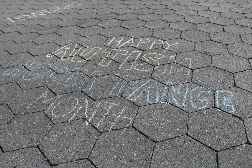 A sidewalk chalk drawing celebrates Autism Acceptance Month in April.