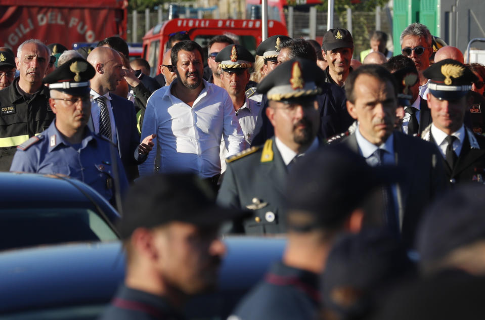 Interior Minister Matteo Salvini, center, arrives at the site where the Morandi highway bridge collapsed, in Genoa, northern Italy, Wednesday, Aug. 15, 2018. A bridge on a main highway linking Italy with France collapsed in the Italian port city of Genoa during a sudden, violent storm, sending vehicles plunging 90 meters (nearly 300 feet) into a heap of rubble below. (AP Photo/Antonio Calanni)