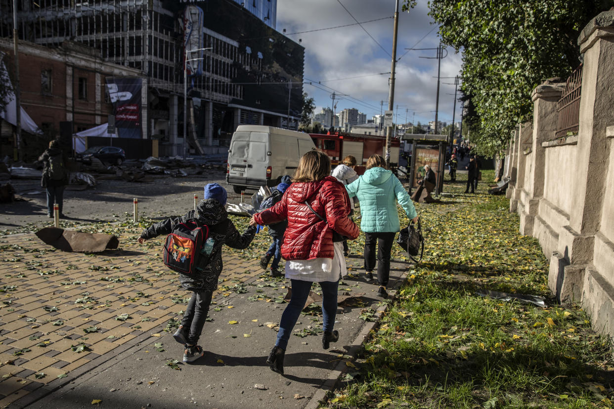 Una familia huye de la escena de un bombardeo ruso en Kiev, Ucrania, el lunes 10 de octubre de 2022. (Finbarr O'Reilly/The New York Times)
