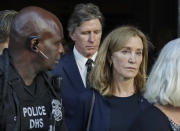 Actress Felicity Huffman leaves federal court accompanied by her brother, Moore Huffman Jr., center, after her sentencing in a nationwide college admissions bribery scandal, Friday, Sept. 13, 2019, in Boston. (AP Photo/Elise Amendola)