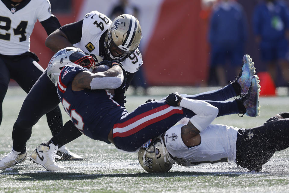 New England Patriots running back Ezekiel Elliott, center, is brought down by New Orleans Saints defensive end Cameron Jordan (94) and cornerback Alontae Taylor, bottom right, during the first half of an NFL football game, Sunday, Oct. 8, 2023, in Foxborough, Mass. (AP Photo/Michael Dwyer)