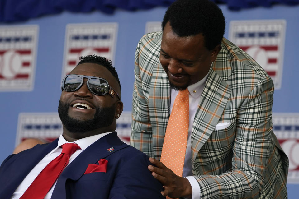 David Ortiz (izquierda), nuevo miembro del Salón de la Fama del béisbol, sonríe junto a Pedro Martínez durante la ceremonia de exaltación, el domingo 24 de julio de 2022 en Cooperstown, Nueva York (AP Foto/John Minchillo)